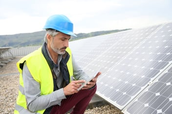 Man using app on phone to monitor solar equipment
